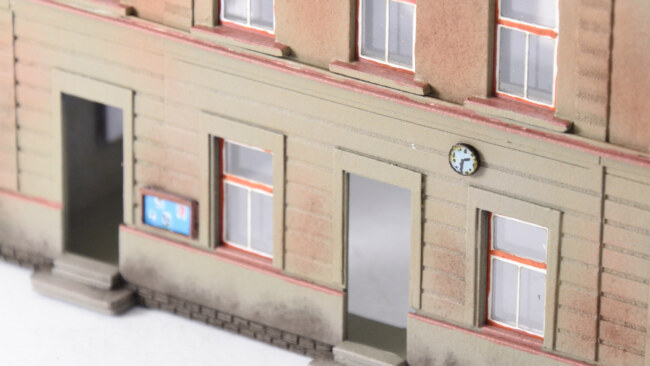 Doplňky nádražní budovy (hodiny, nástěnky, revizní dvířka)